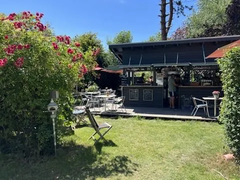 Rosen und Tische im Garten vor dem Café-Pavillon